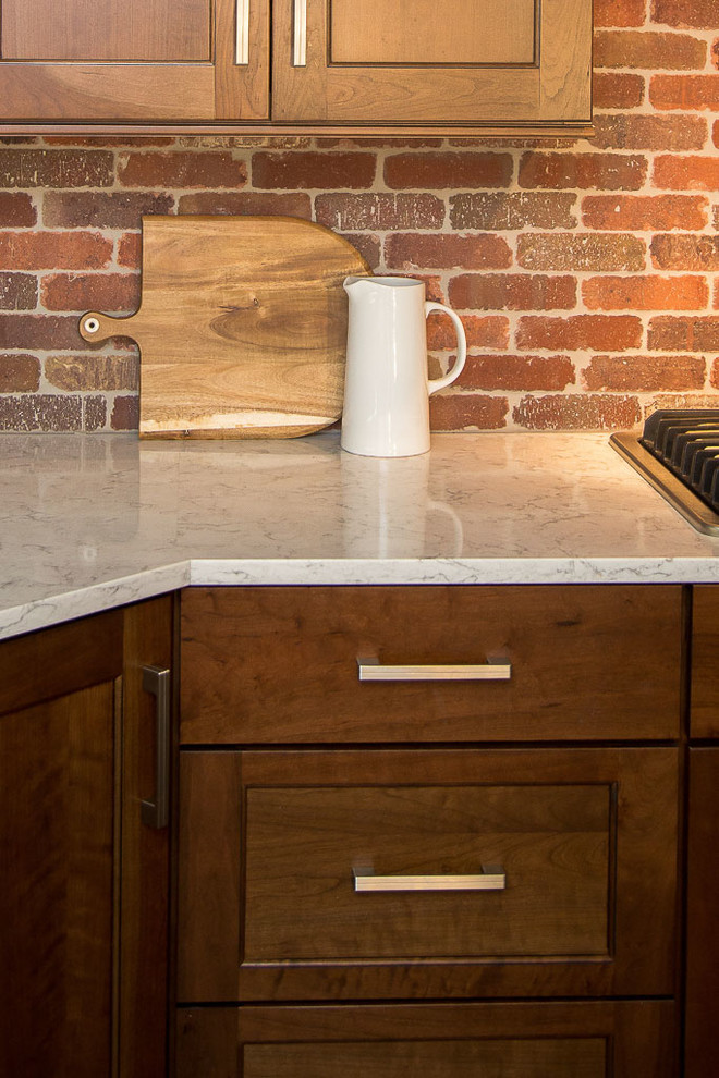 Large mountain style l-shaped dark wood floor eat-in kitchen photo in Denver with a farmhouse sink, shaker cabinets, dark wood cabinets, quartz countertops, red backsplash, terra-cotta backsplash, stainless steel appliances and an island