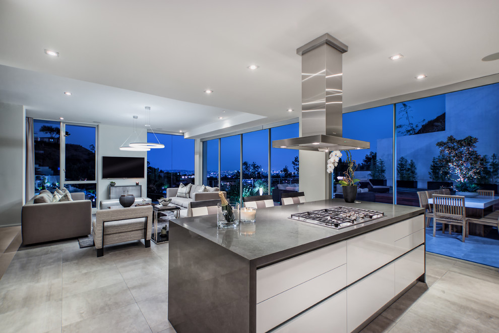 Mid-sized contemporary l-shaped kitchen in Los Angeles with an undermount sink, flat-panel cabinets, medium wood cabinets, quartz benchtops, white splashback, ceramic splashback, white appliances, porcelain floors and with island.