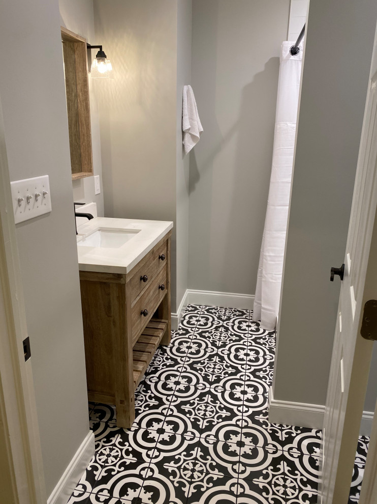 Foto på ett litet lantligt vit badrum, med släta luckor, skåp i ljust trä, en hörndusch, en toalettstol med hel cisternkåpa, vit kakel, grå väggar, ett integrerad handfat och dusch med duschdraperi