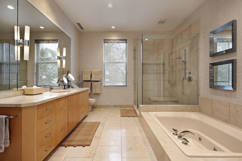 This is an example of a large master bathroom in Los Angeles with flat-panel cabinets, medium wood cabinets, a hot tub, a corner shower, a bidet, beige tile, stone tile, travertine floors, an undermount sink and marble benchtops.