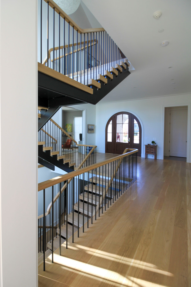 Inspiration for an expansive modern wood floating staircase in DC Metro with mixed railing and planked wall panelling.