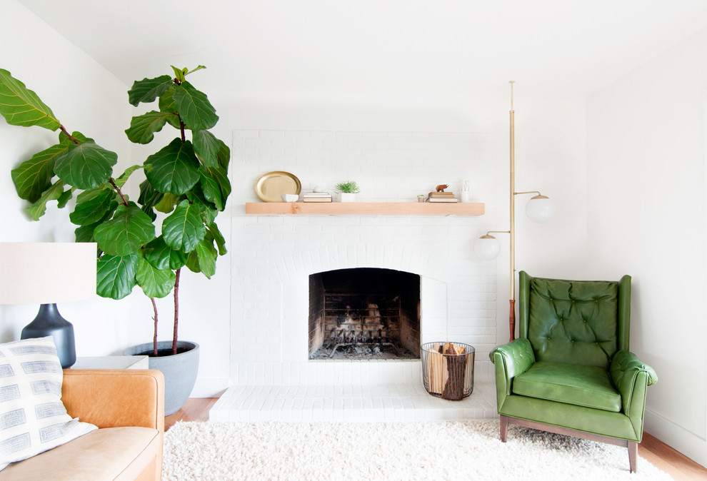 Mid-sized midcentury open concept living room in Denver with white walls, light hardwood floors, a standard fireplace, a brick fireplace surround and no tv.
