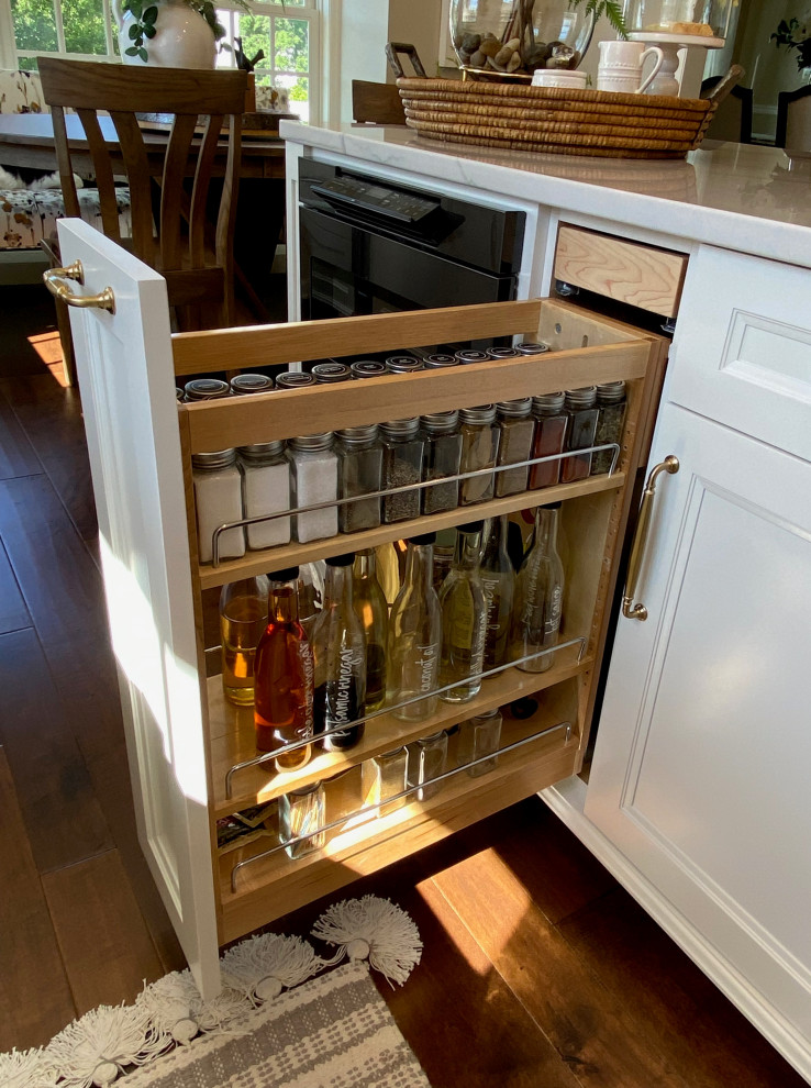 This is an example of a large transitional l-shaped kitchen pantry in Other with an undermount sink, flat-panel cabinets, white cabinets, quartzite benchtops, white splashback, mosaic tile splashback, stainless steel appliances, dark hardwood floors, with island, brown floor and white benchtop.