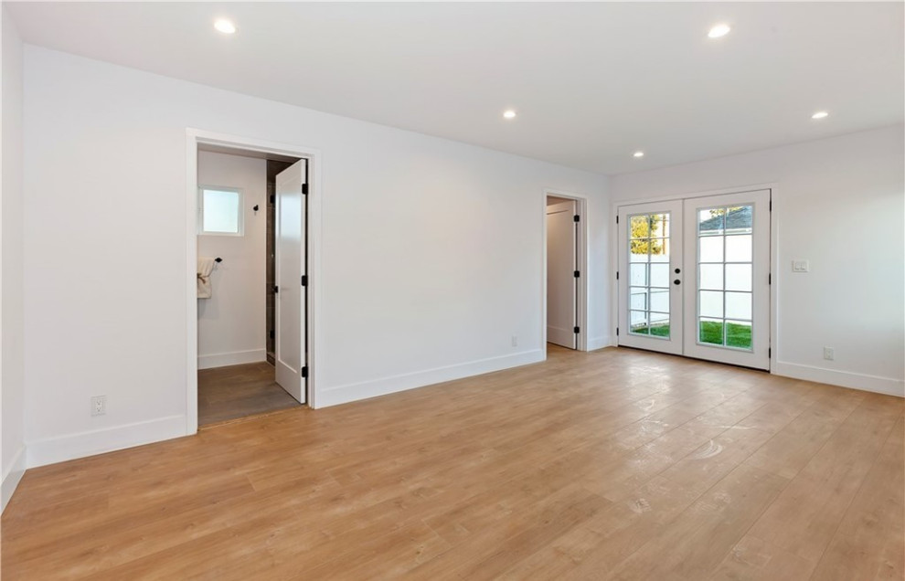 Exemple d'une chambre parentale tendance avec un mur blanc, un sol en bois brun et un sol marron.