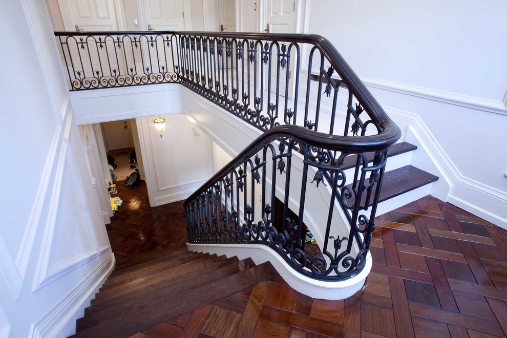 This is an example of a mid-sized mediterranean wood l-shaped staircase in Toronto with painted wood risers.
