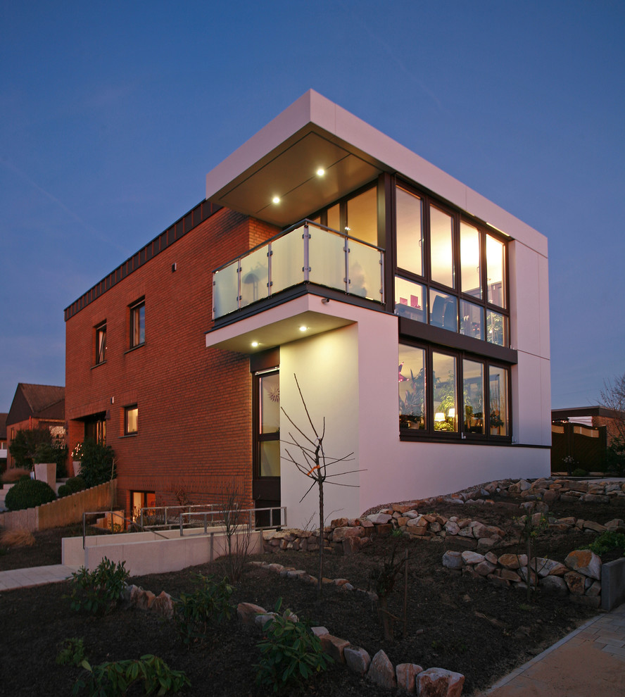 This is an example of an expansive contemporary two-storey stucco white exterior in Other with a flat roof and a mixed roof.