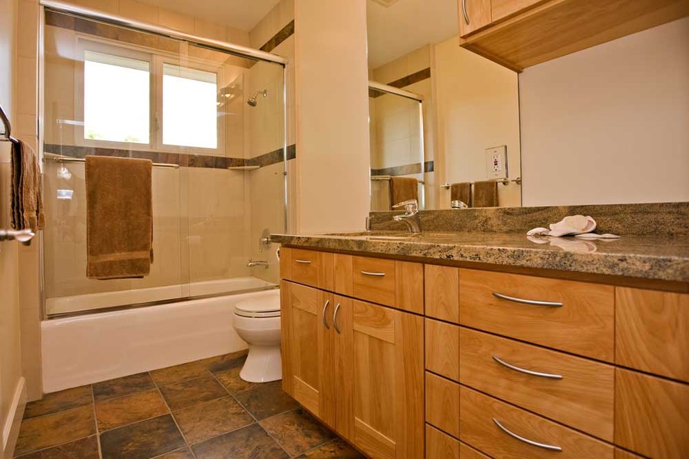 Mid-sized trendy brown tile and stone tile slate floor bathroom photo in San Francisco with an undermount sink, recessed-panel cabinets, light wood cabinets, granite countertops, a one-piece toilet and white walls