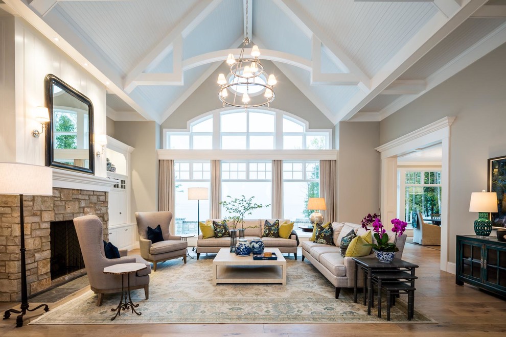 Inspiration for a large traditional formal open concept living room in Denver with grey walls, medium hardwood floors, a standard fireplace, a stone fireplace surround and brown floor.