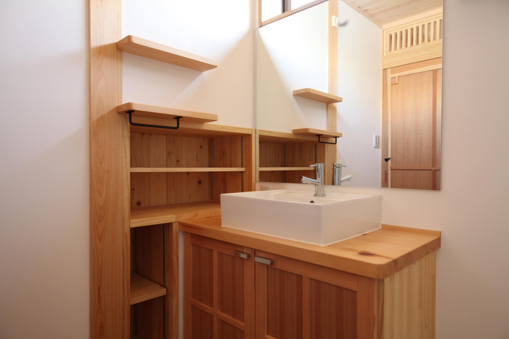 Inspiration for a medium sized world-inspired cloakroom in Other with freestanding cabinets, orange cabinets, white walls, a vessel sink, wooden worktops, orange worktops and a built in vanity unit.