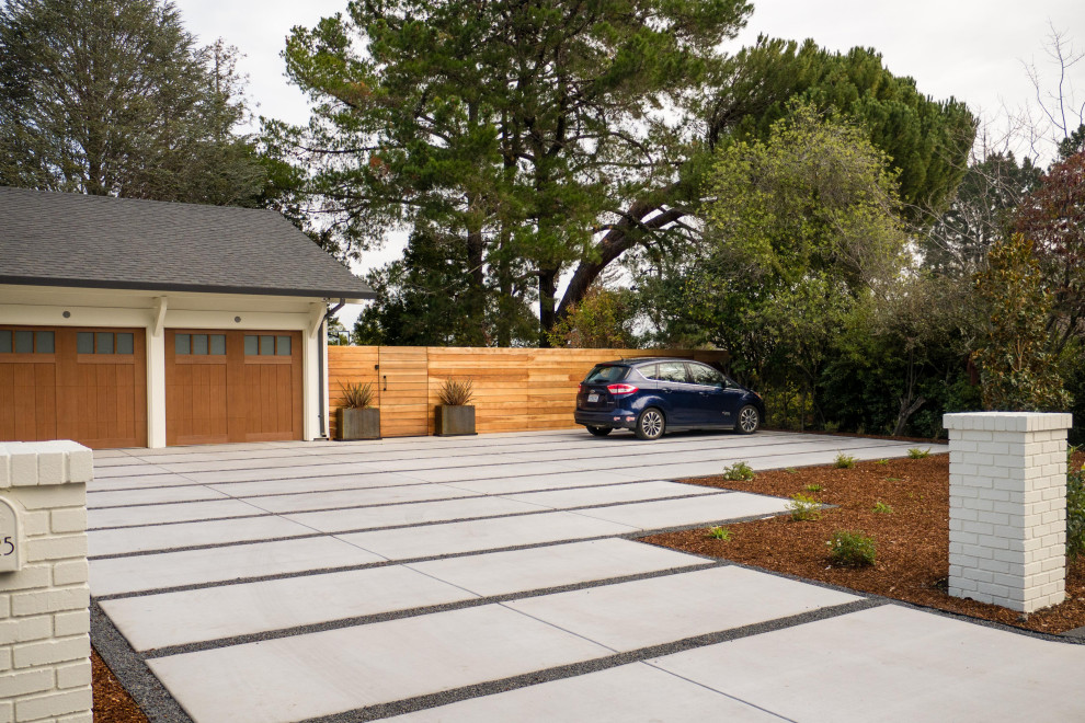 Design ideas for a large contemporary front yard full sun driveway in San Francisco with concrete pavers, a wood fence and with a gate.