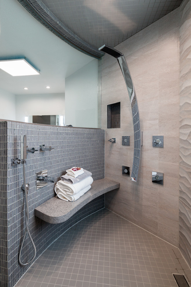 Photo of a mid-sized contemporary master bathroom in Dallas with flat-panel cabinets, grey cabinets, a drop-in tub, a double shower, a two-piece toilet, black tile, gray tile, mosaic tile, grey walls, porcelain floors, an integrated sink and solid surface benchtops.