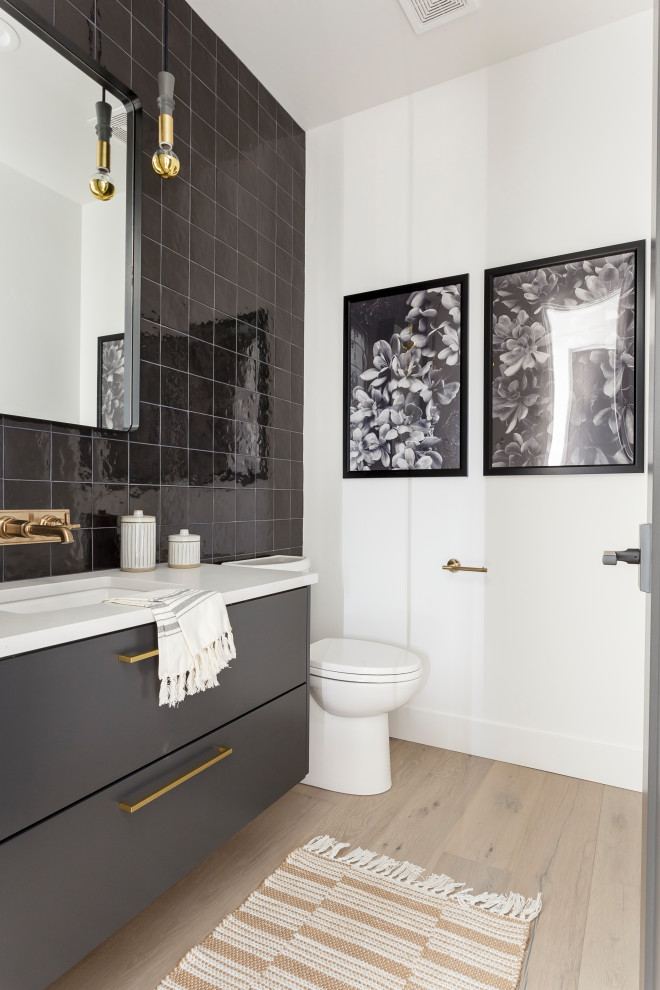This is an example of a contemporary powder room in Boise with flat-panel cabinets, grey cabinets, white walls, light hardwood floors, an undermount sink, beige floor, white benchtops and a floating vanity.