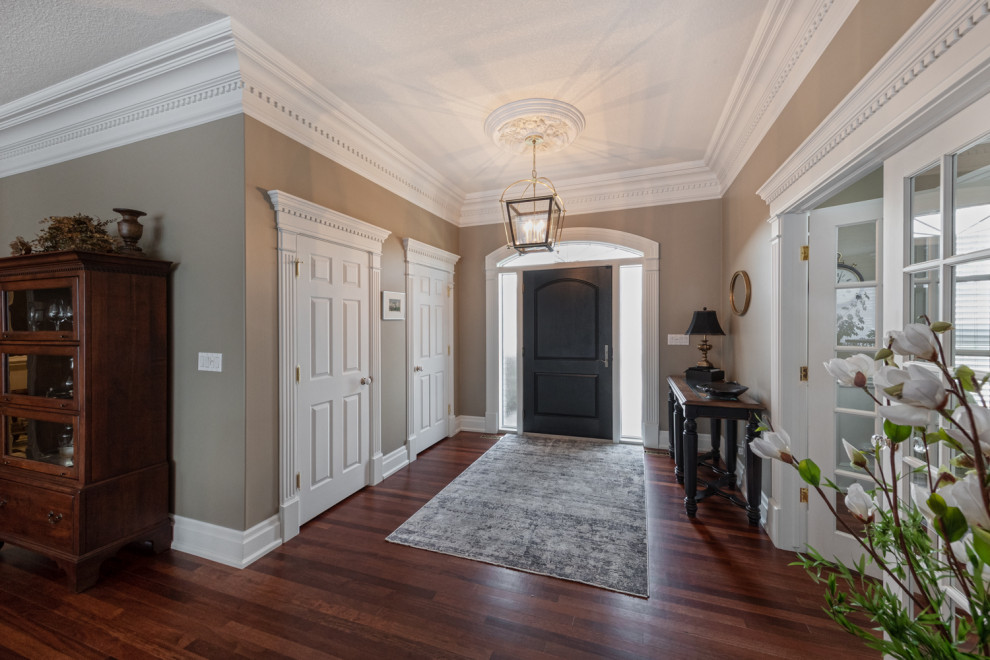 Mittelgroßes Klassisches Foyer mit beiger Wandfarbe, dunklem Holzboden, Einzeltür, schwarzer Haustür und braunem Boden in Edmonton