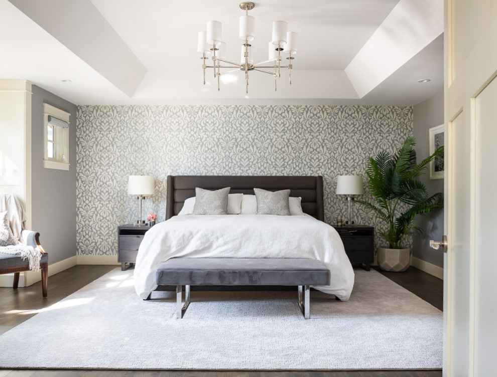 Imagen de dormitorio principal y abovedado moderno grande sin chimenea con paredes grises, suelo de madera oscura, suelo marrón, bandeja y papel pintado