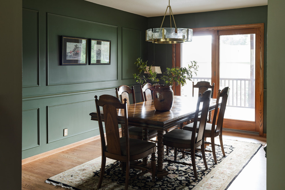 Inspiration for a mid-sized transitional medium tone wood floor, brown floor and wall paneling enclosed dining room remodel with green walls