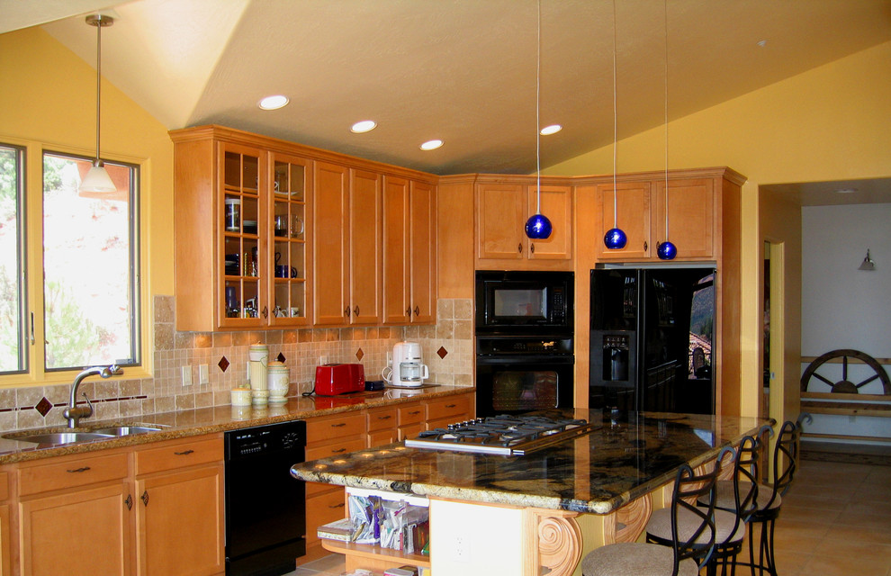 Example of a transitional galley eat-in kitchen design in Phoenix with an undermount sink, granite countertops, stone tile backsplash, stainless steel appliances and an island