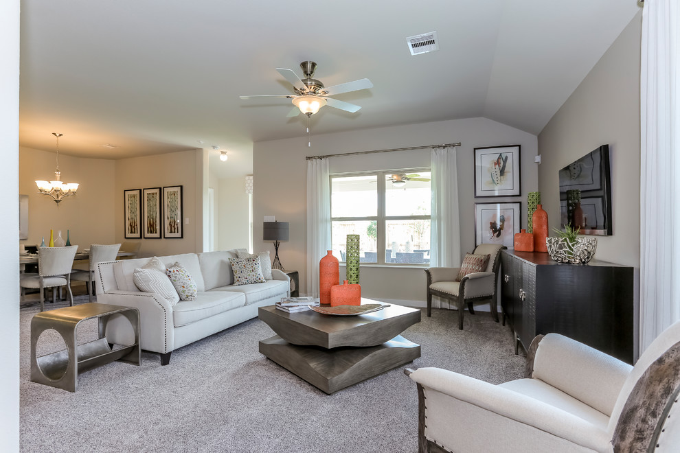 Photo of a large transitional open concept living room in Houston with beige walls, carpet, a wall-mounted tv and beige floor.