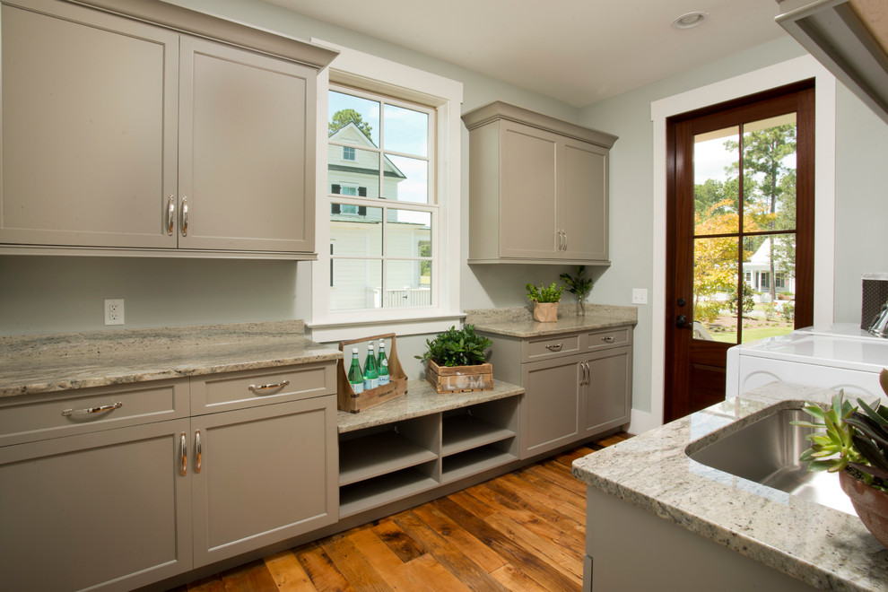 Large traditional galley utility room in Charleston with an undermount sink, shaker cabinets, beige cabinets, granite benchtops, medium hardwood floors, a side-by-side washer and dryer, brown floor and grey walls.