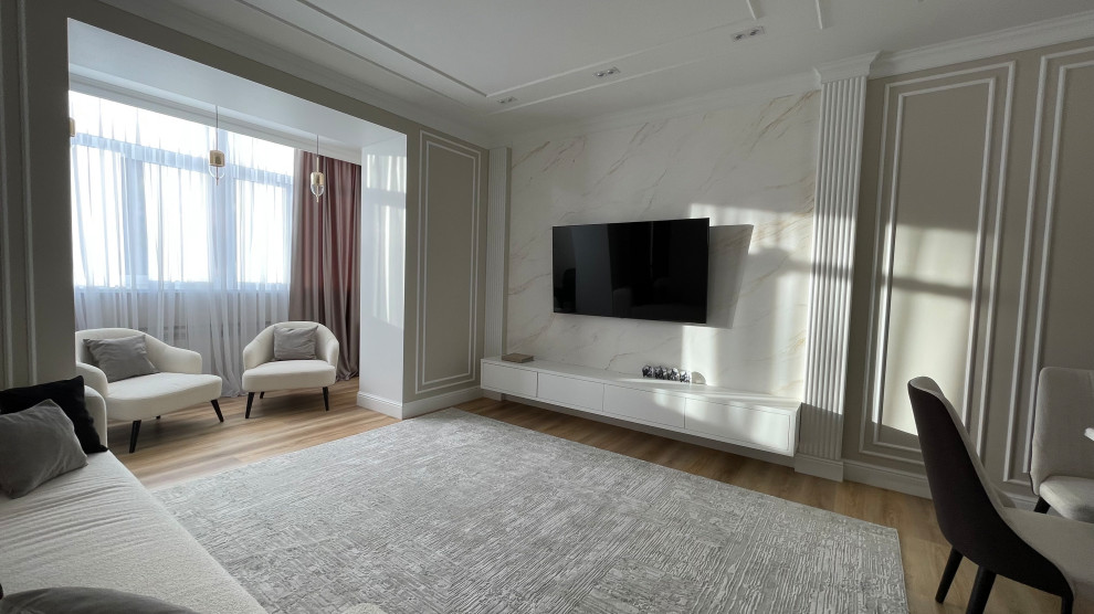 Modern inredning av ett stort vardagsrum, med beige väggar, laminatgolv och en väggmonterad TV