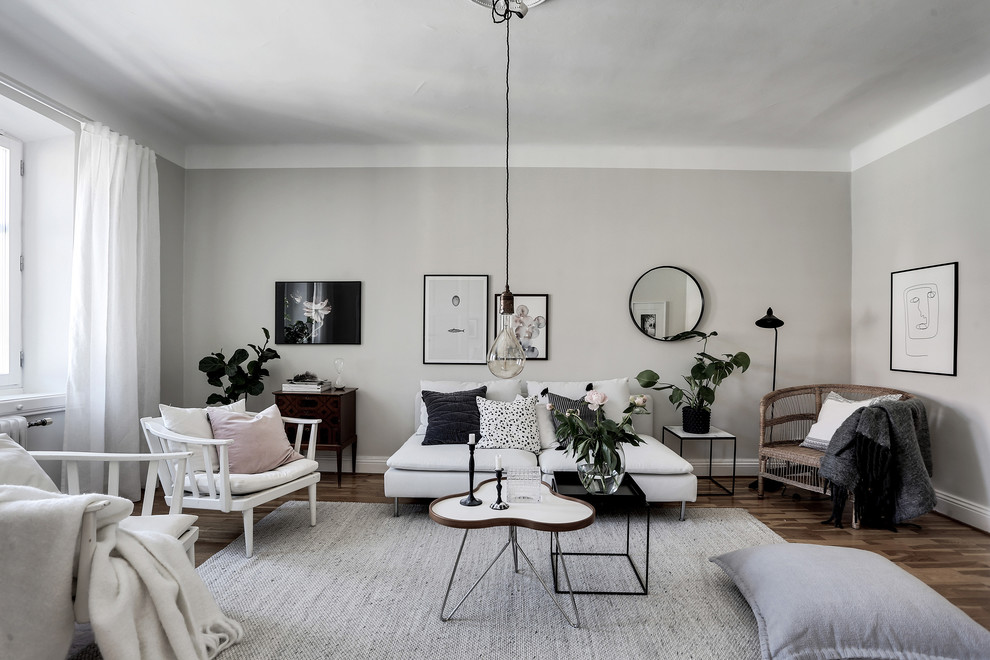 Inspiration for a traditional living room in Gothenburg with white walls and medium hardwood floors.