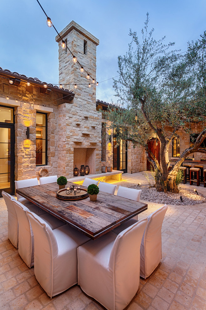 Inspiration for a mediterranean patio in San Diego with brick pavers and a fire feature.
