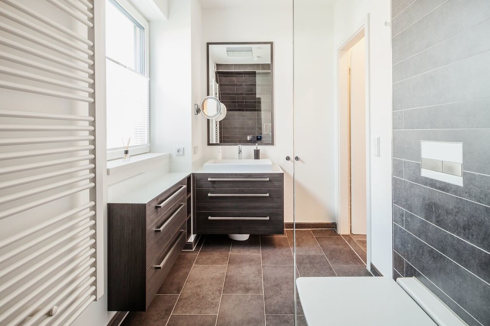 Inspiration for a small contemporary 3/4 bathroom in Dortmund with flat-panel cabinets, dark wood cabinets, a curbless shower, a wall-mount toilet, green tile, ceramic tile, white walls, ceramic floors and engineered quartz benchtops.