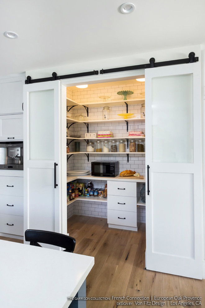 Inspiration for a scandinavian kitchen pantry in Los Angeles with open cabinets, white cabinets and light hardwood floors.
