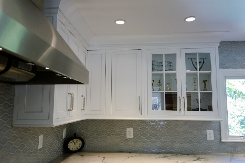 Example of a large transitional u-shaped eat-in kitchen design in DC Metro with white cabinets, an island, glass-front cabinets, gray backsplash and porcelain backsplash