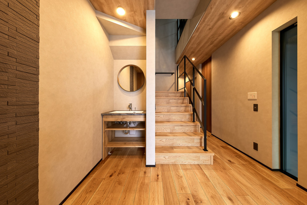 Bild på en entré, med grå väggar och plywoodgolv