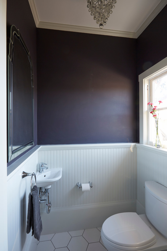 This is an example of a small arts and crafts powder room in San Francisco with a two-piece toilet, white tile, porcelain tile, purple walls, porcelain floors and a wall-mount sink.