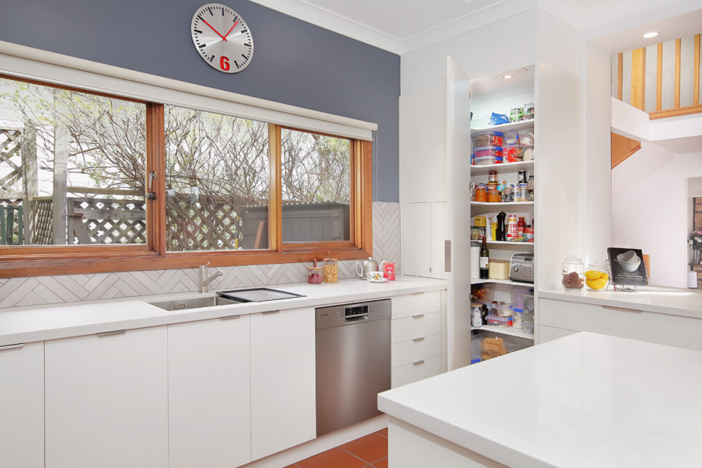 Inspiration for a mid-sized contemporary u-shaped eat-in kitchen in Sydney with an undermount sink, glass-front cabinets, white cabinets, quartz benchtops, beige splashback, ceramic splashback, stainless steel appliances, cement tiles, with island and white benchtop.