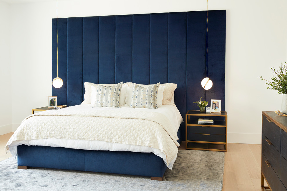 Inspiration for a modern bedroom in Toronto with white walls and light hardwood floors.
