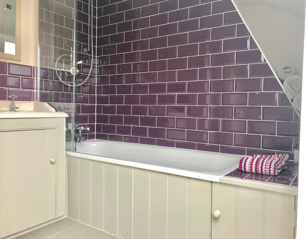Small eclectic kids bathroom in London with flat-panel cabinets, grey cabinets, a drop-in tub, multi-coloured tile, porcelain tile, purple walls, porcelain floors, a drop-in sink, beige floor, a hinged shower door and white benchtops.