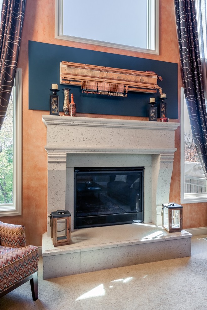 Expansive transitional formal open concept living room in Omaha with orange walls, carpet, a standard fireplace, a stone fireplace surround and no tv.