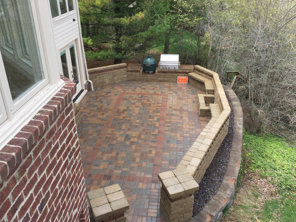 Photo of a large transitional backyard patio in Detroit with an outdoor kitchen, brick pavers and no cover.