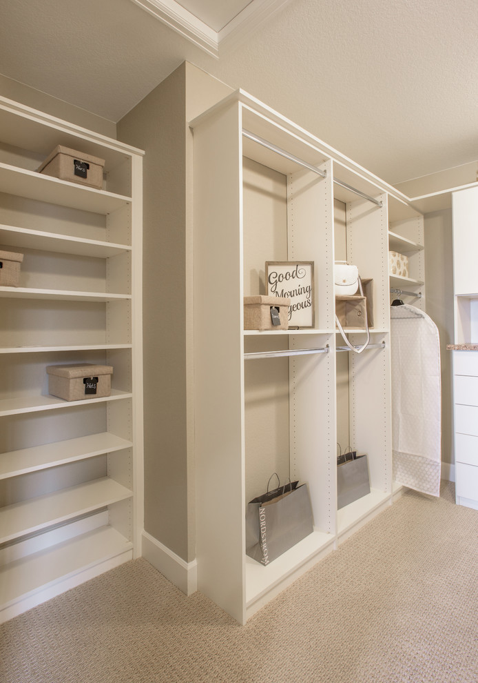 Mid-sized transitional gender-neutral walk-in wardrobe in Denver with flat-panel cabinets, white cabinets, carpet and beige floor.