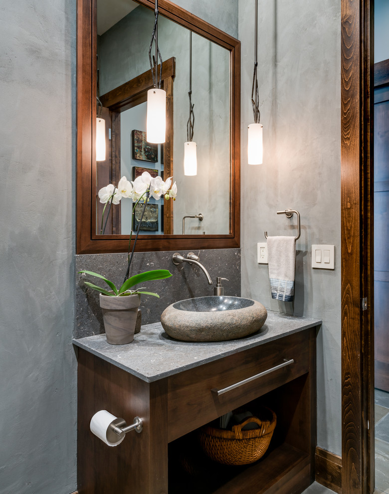 Large transitional powder room in Other with shaker cabinets, dark wood cabinets, a one-piece toilet, gray tile, stone tile, grey walls, a vessel sink and limestone benchtops.