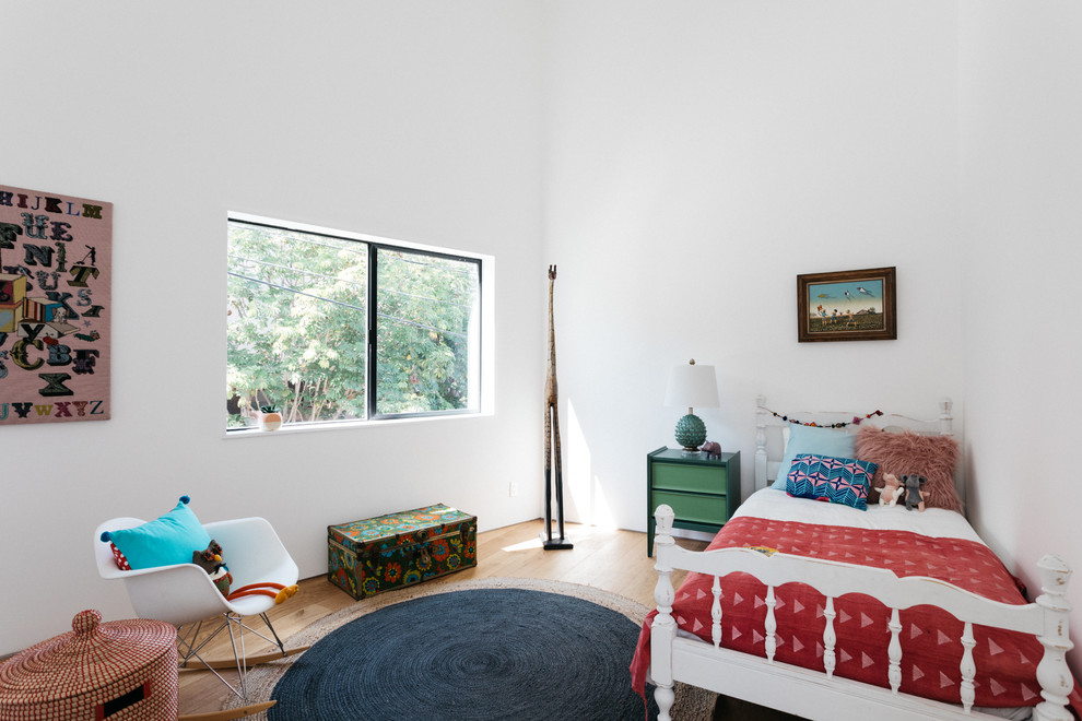 Photo of a contemporary kids' room in Los Angeles with white walls, medium hardwood floors and brown floor.