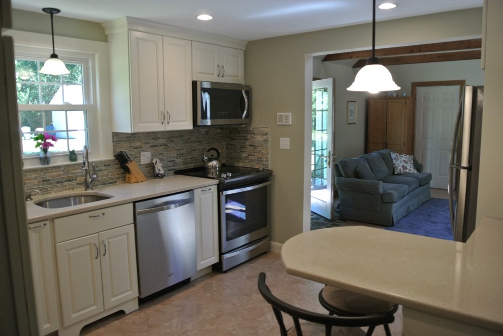 Kitchen - transitional u-shaped porcelain tile and beige floor kitchen idea in Boston with an undermount sink, raised-panel cabinets, white cabinets, beige backsplash, subway tile backsplash and stainless steel appliances
