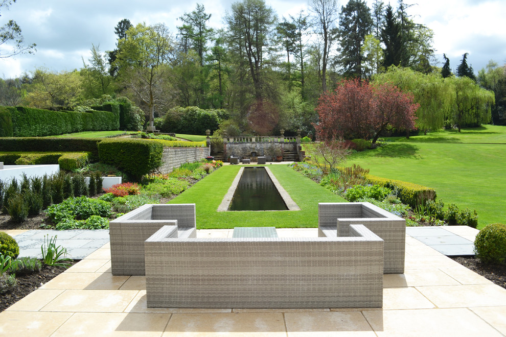 Traditional formal garden in Other with with pond.