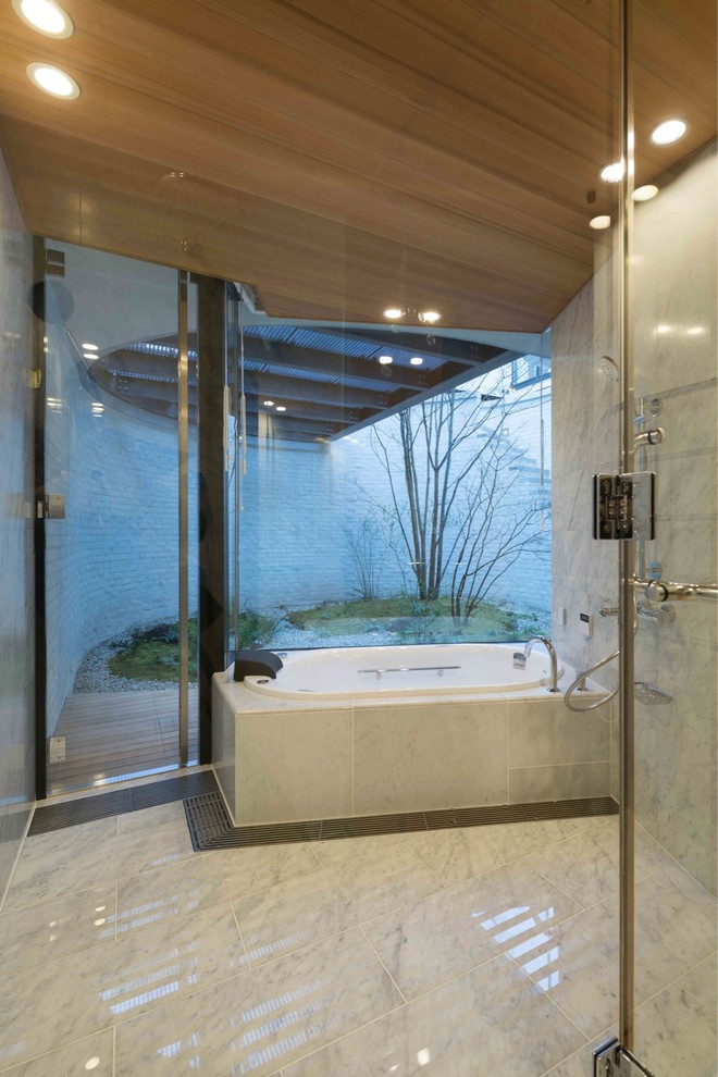 This is an example of a contemporary bathroom in Tokyo with a drop-in tub.