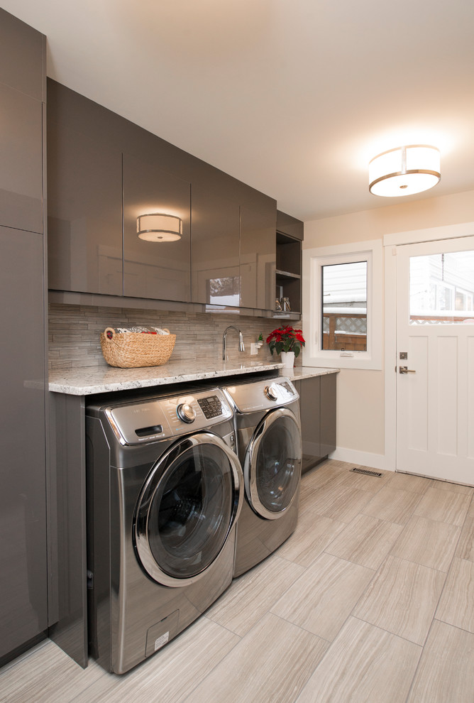 Mid-sized transitional single-wall dedicated laundry room in Calgary with flat-panel cabinets, grey cabinets, beige walls, a side-by-side washer and dryer, an undermount sink, quartz benchtops, porcelain floors, grey floor and beige benchtop.
