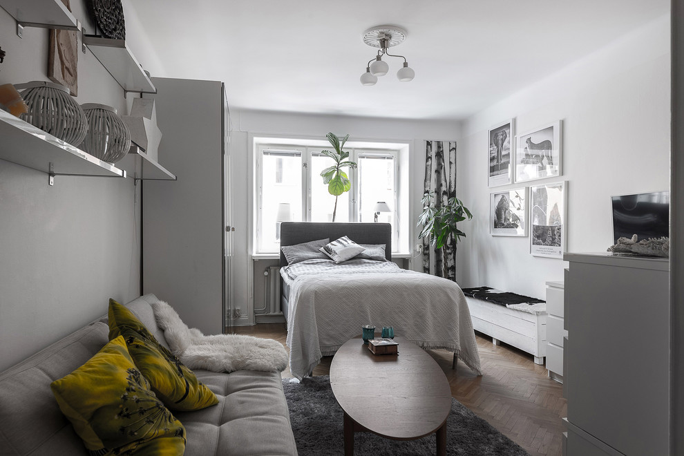 Photo of a mid-sized scandinavian master bedroom in Stockholm with white walls, light hardwood floors and beige floor.