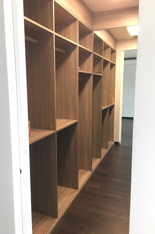 Design ideas for a mid-sized contemporary walk-in wardrobe in Miami with raised-panel cabinets, medium wood cabinets, dark hardwood floors and brown floor.