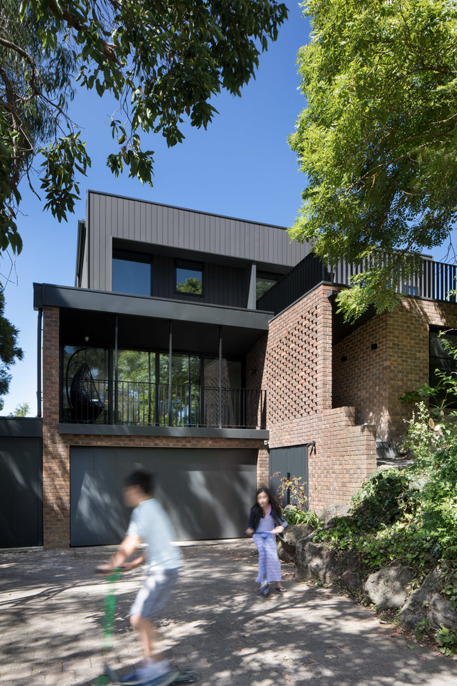Large contemporary three-storey brick brown exterior in Melbourne with a flat roof.