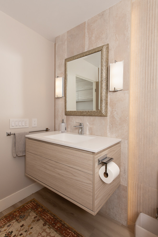 Cette photo montre un WC et toilettes moderne en bois clair avec un placard à porte plane, un bidet, un mur beige, un sol en vinyl, un lavabo intégré, un plan de toilette en quartz, un sol marron, un plan de toilette blanc et meuble-lavabo suspendu.