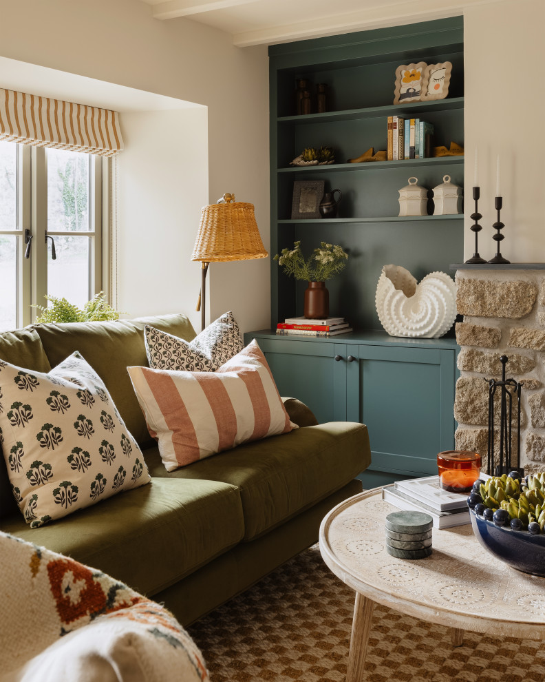 Inspiration for a small eclectic living room in Cornwall with a library, beige walls, medium hardwood floors, a wood stove, a brick fireplace surround, a wall-mounted tv, brown floor and exposed beam.
