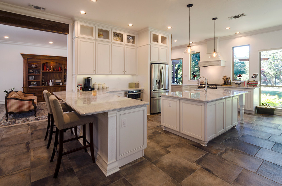 Inspiration for a large country galley eat-in kitchen in Austin with a farmhouse sink, recessed-panel cabinets, white cabinets, marble benchtops, white splashback, stainless steel appliances, slate floors and a peninsula.