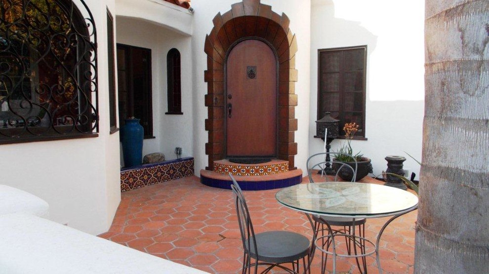 This is an example of a mid-sized mediterranean one-storey adobe white exterior in Los Angeles with a gable roof.
