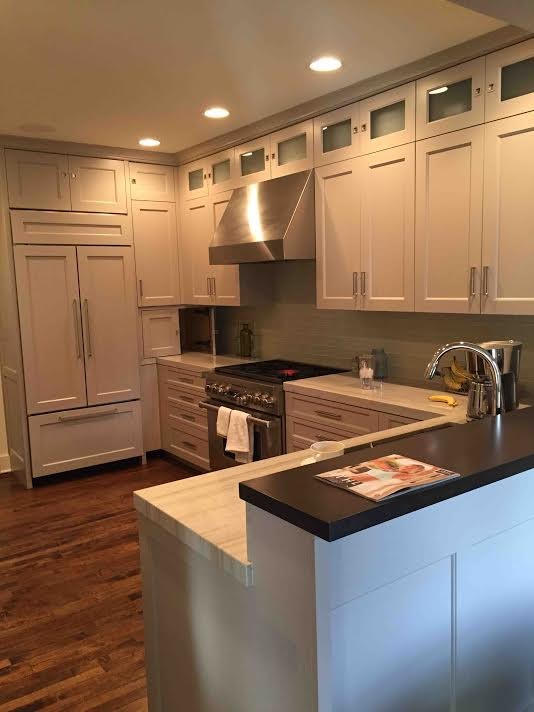 Inspiration for a mid-sized transitional u-shaped dark wood floor eat-in kitchen remodel in Orange County with a double-bowl sink, raised-panel cabinets, white cabinets, marble countertops, beige backsplash, ceramic backsplash, stainless steel appliances and no island
